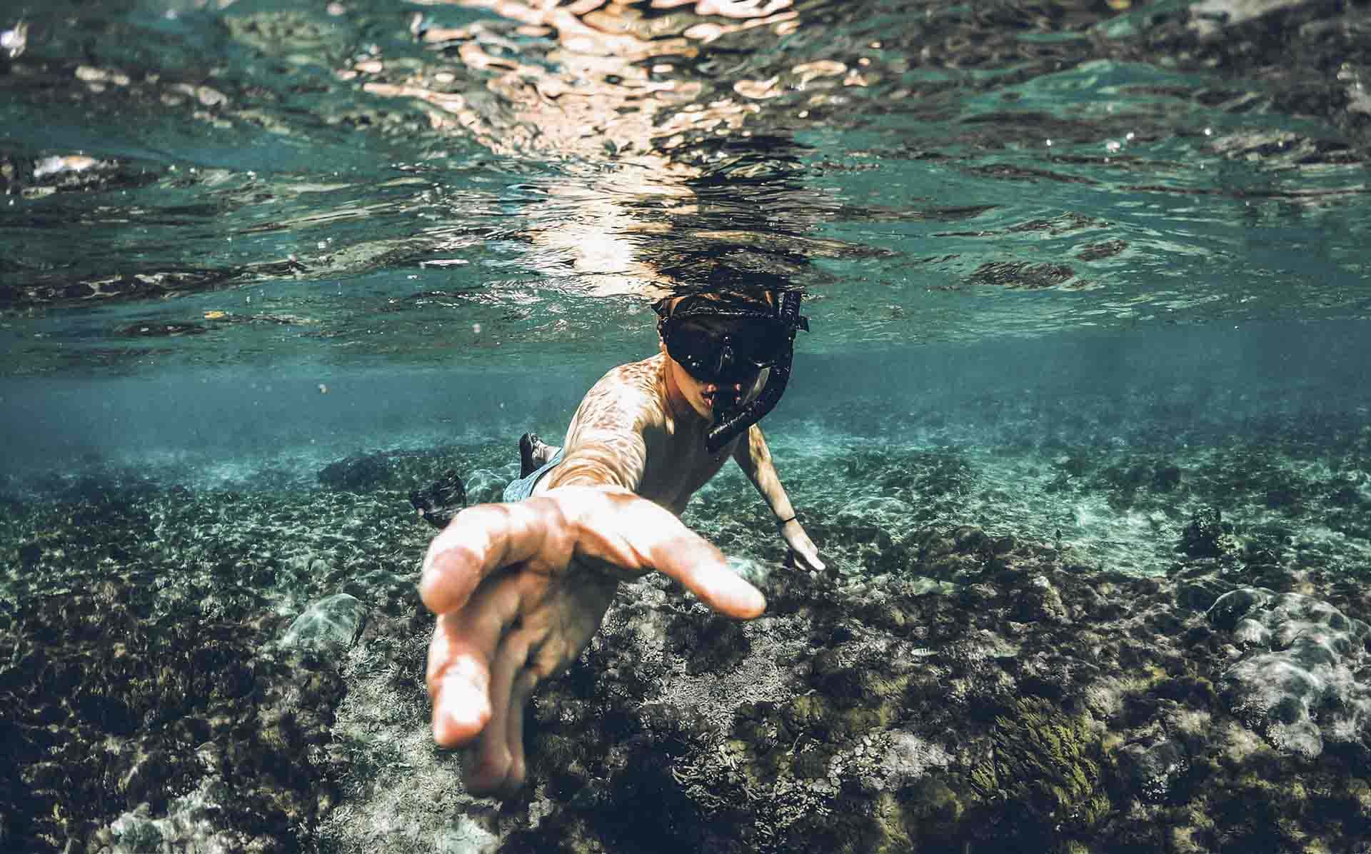 Snorkeler swimming over a shallow reef