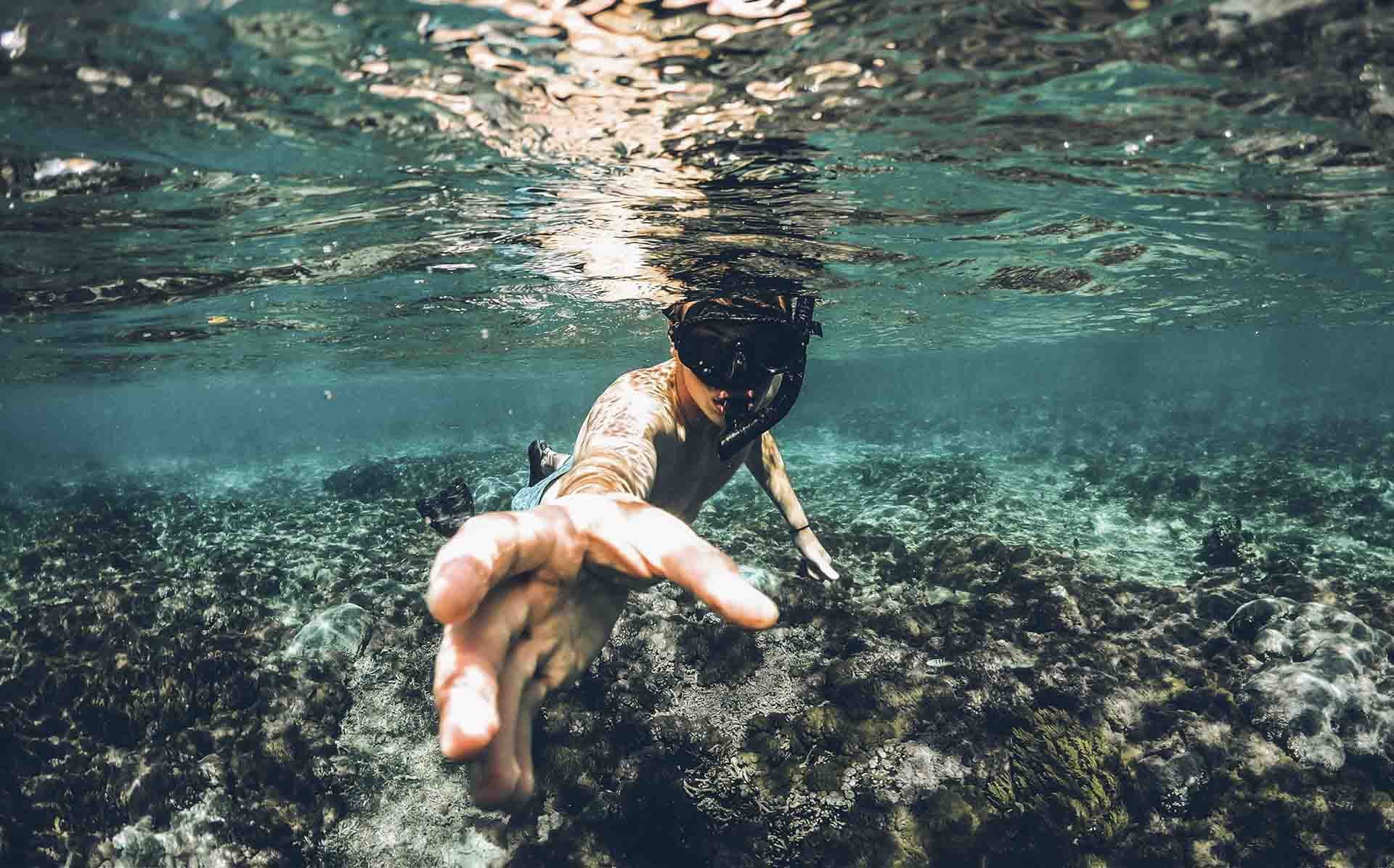 Snorkeler swimming over a shallow reef